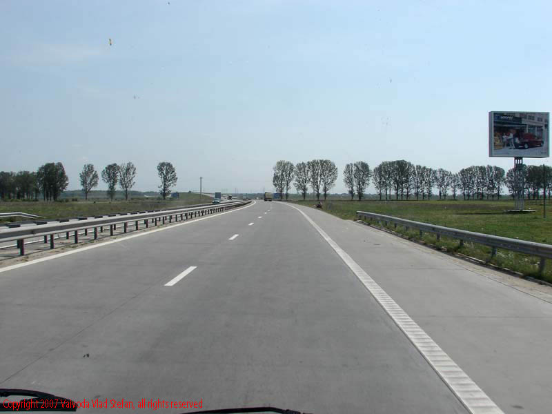 Vaivoda Vlad fotograf in Romania drum european national sosea sosele excursie calatorie calator voiaj masina automobil condus sofat soferie circula circulatie daewoo matiz autostrada autostrazi rutier liber copaci marcaj parapet copaci copac pom pomi iarba cer senin vara Peisaj panorama A2 spre Constanta 2007